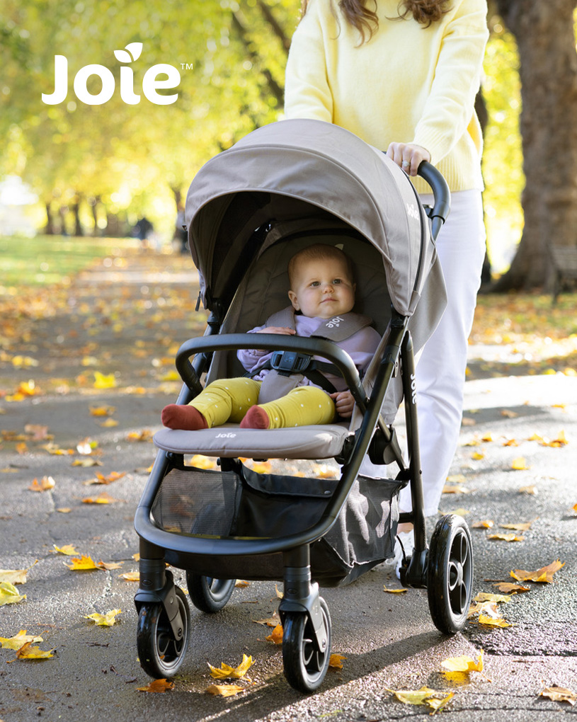Baby i grå "Joie"-vogn på efterårstur med voksen.